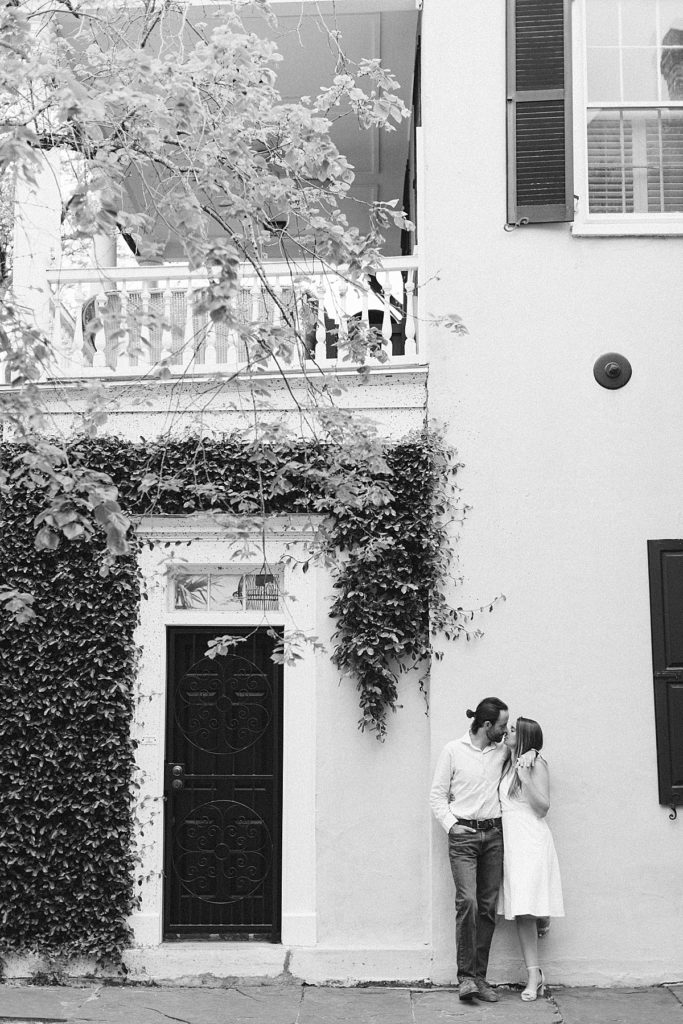 Couple kissing next to door from Charleston, South Carolina engagement session. Rachel Fugate Photography