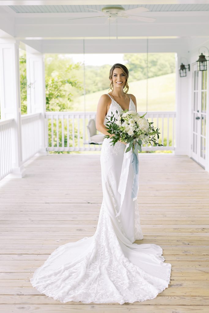 Bride on Mint Springs Farm porch with bouquet. Rachel Fugate Photography